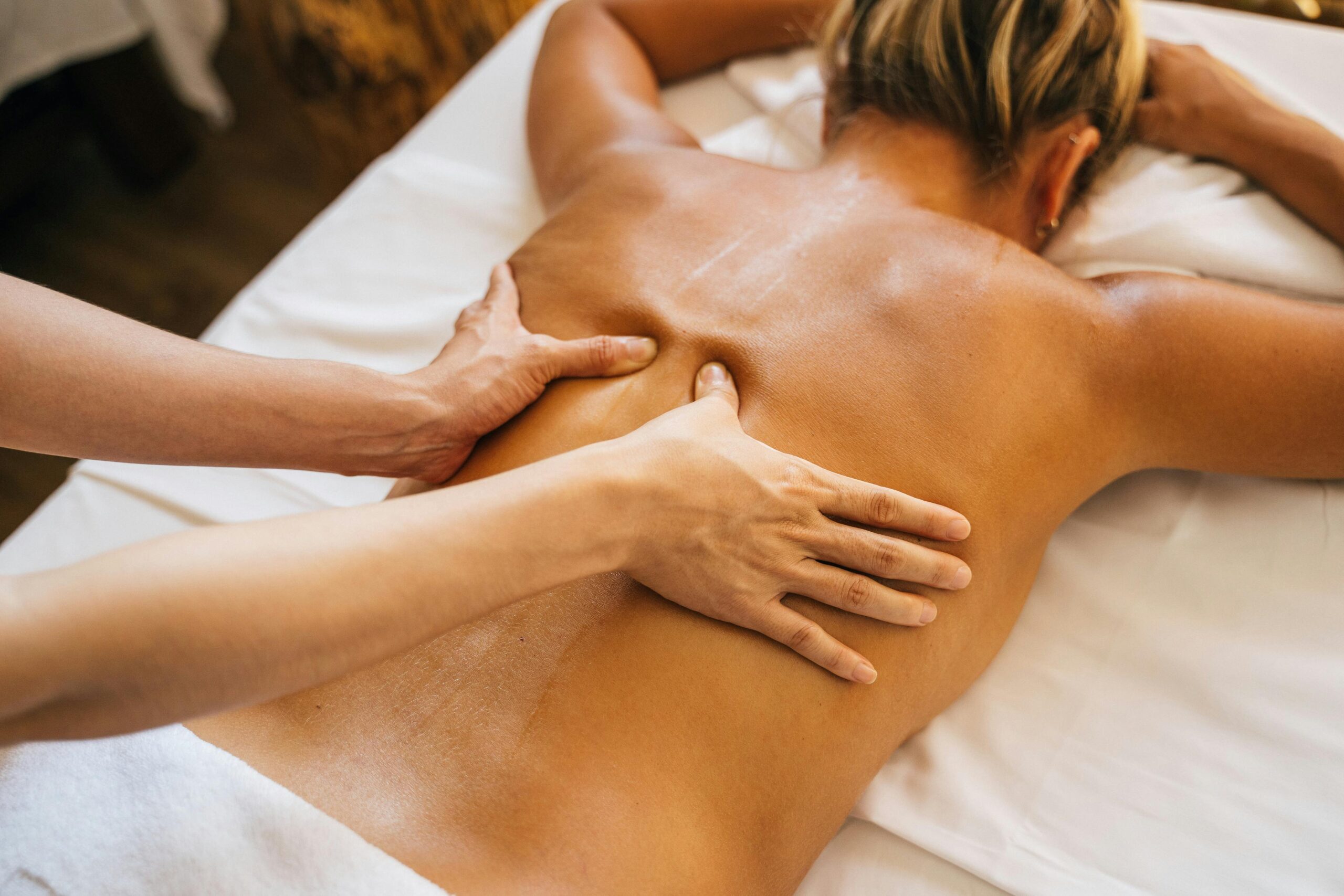 Close-up of a relaxing massage therapy session at a spa with focus on back and hands.